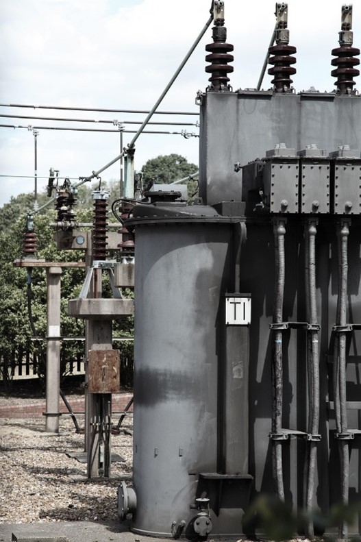 Image of a pad-mount transformer mounted outside of a facility.